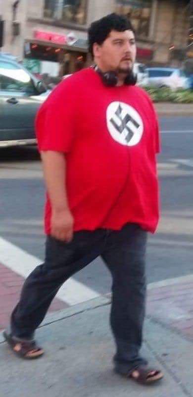 A man resembling Dough Benson wears his XXL nazi tee on a public sidewalk in the French Provinces. (Facebook)
