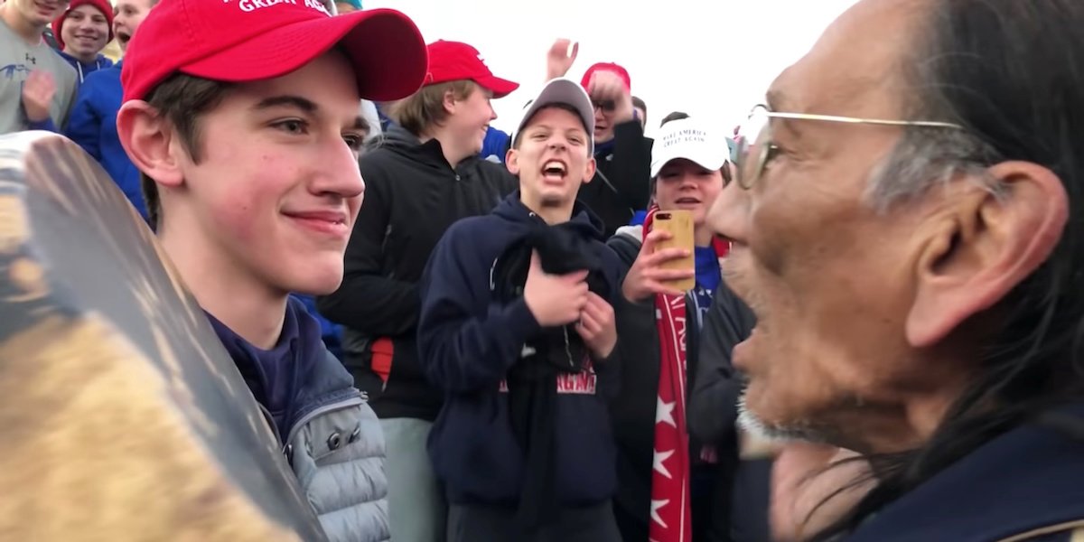 chronicle.su: MAGAface confronts a Navajo Code Talker during his pro-life rally. A boy in the background respectfully chants along with Phillips. After this picture was taken everyone stood and clapped.